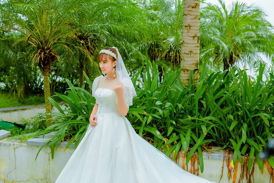 A bride in a white wedding dress posing for a picture.